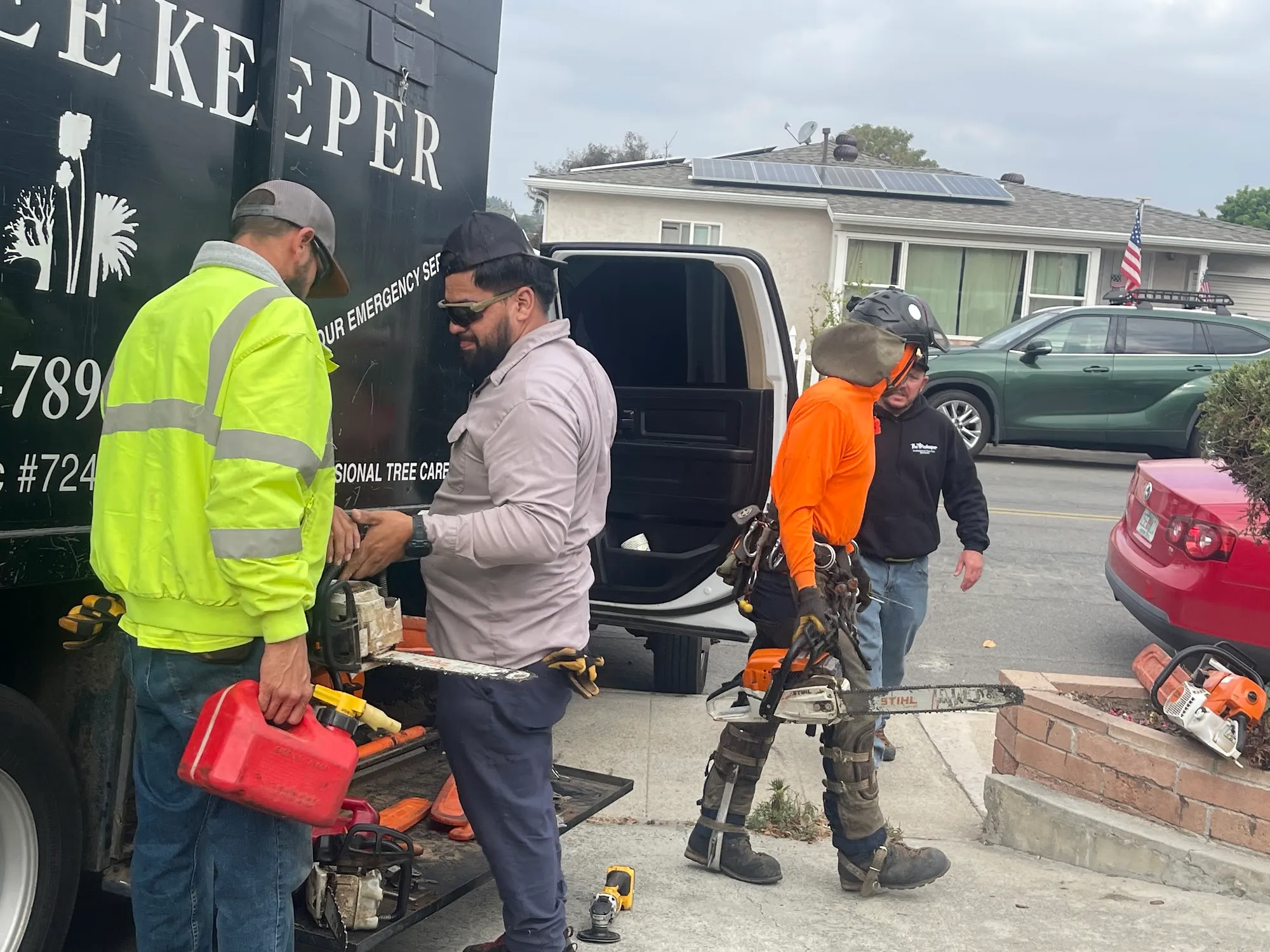 Tree Keeper crew gearing up with saws and climbing gear at the company truck